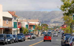 Street level view of San Bruno businesses with hills and light fog